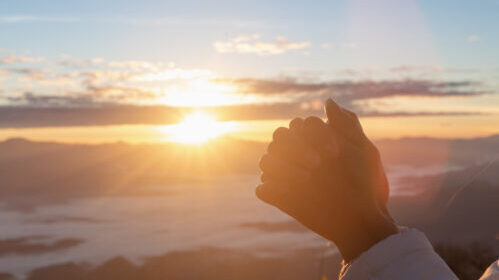 Christian woman  hands praying to god on the mountain background